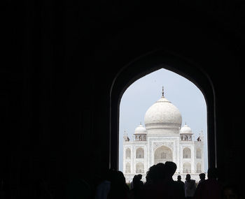 Group of silhouette people in front of historical building