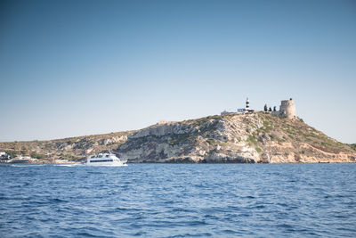 Scenic view of sea by building against clear sky