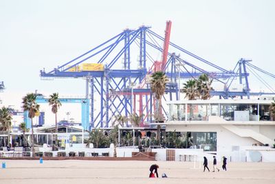 People at pier against clear sky