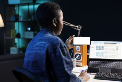 Side view of man using laptop at home