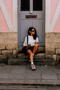 Full length of woman sitting on staircase