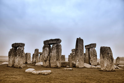 Stonehenge on field against sky