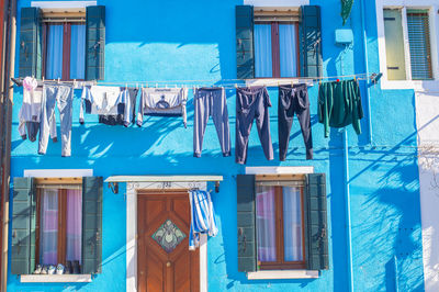 Clothes drying against blue building