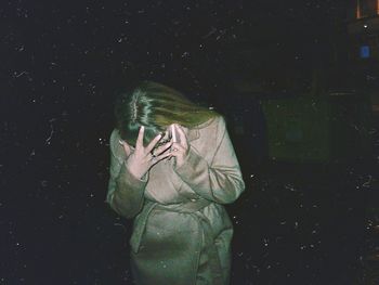 Person wearing mask against black background