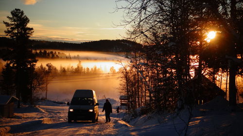 Car on snowcapped landscape at dusk