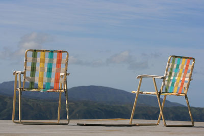 Colorful empty chairs against mountains