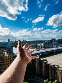 Midsection of woman by buildings against sky in city