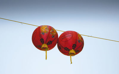 Low angle view of lanterns hanging against clear sky