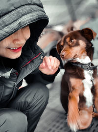 Midsection of woman with dog sitting outdoors