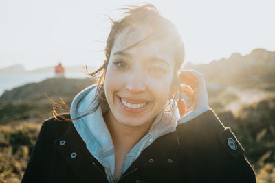 Portrait of young woman against sky