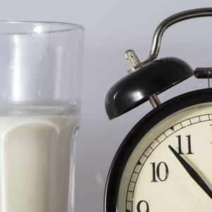 Close-up of milk by alarm against white background