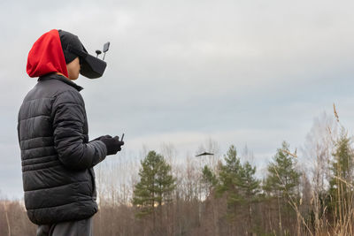 Young man launches rc plane into sky. teenager with glasses playing with toy radio-controlled 