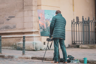 Full length of young man standing against wall