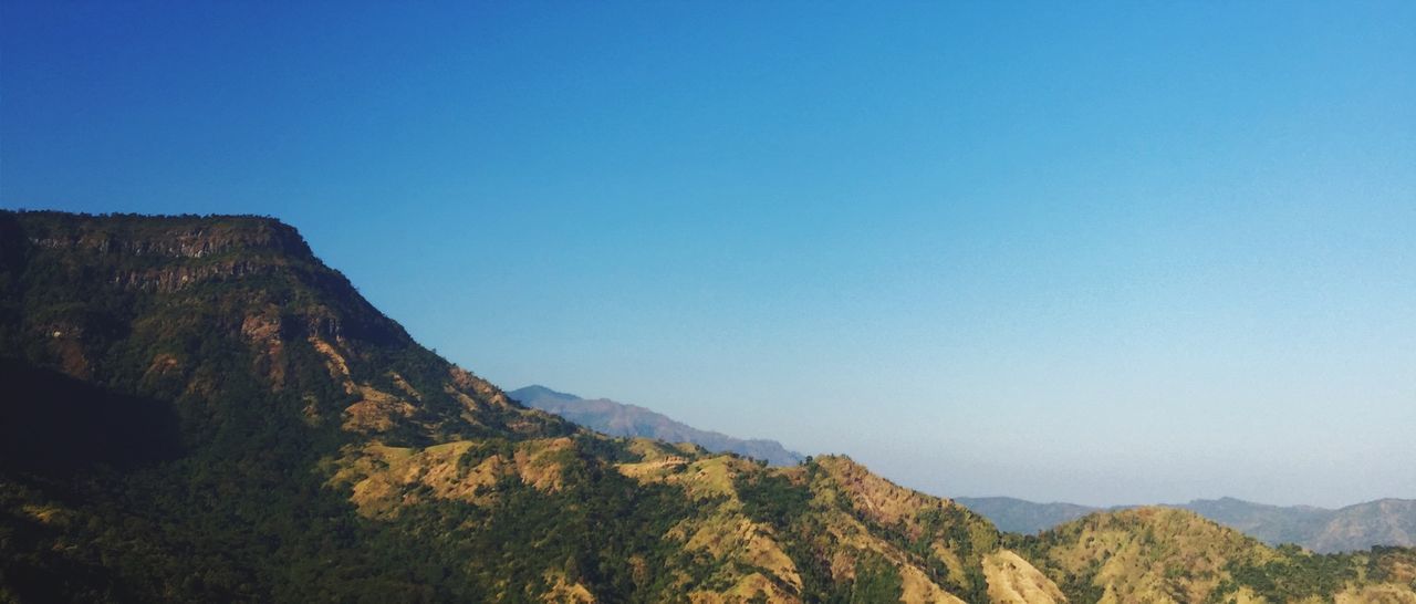 clear sky, mountain, copy space, tranquil scene, blue, tranquility, scenics, beauty in nature, landscape, nature, mountain range, non-urban scene, idyllic, rock formation, physical geography, tree, geology, remote, rocky mountains, rock - object