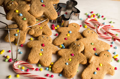 Close-up of gingerbread cookies with cutter and candy cane on table