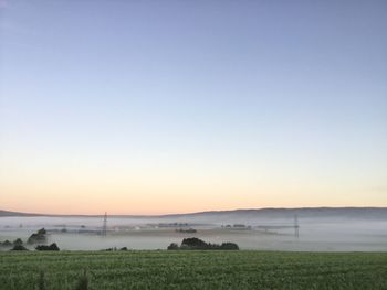 Scenic view of field against clear sky during sunset