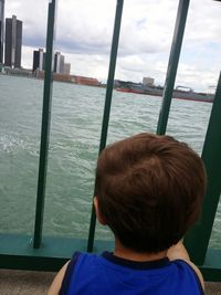 Boy looking at sea against sky