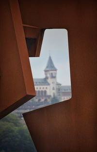 Close-up of buildings against sky seen through window