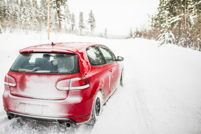 Red car on snow covered land