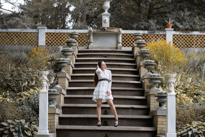 Full length of young woman standing on staircase