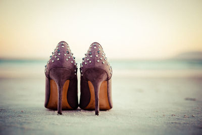 Close-up of shoes on beach