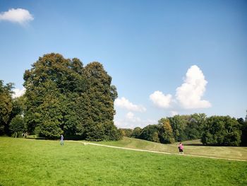 People playing soccer on field against sky