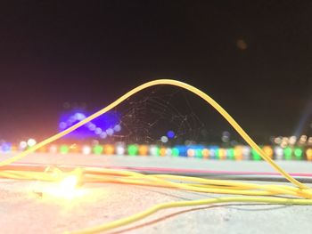 Light trails on road against sky at night