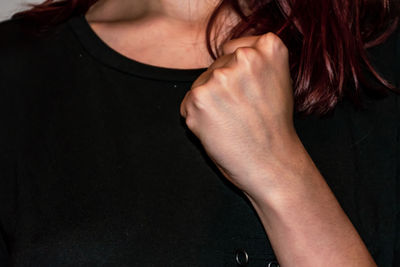 Close-up of woman hand over black background