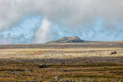 Scenic view of landscape against cloudy sky