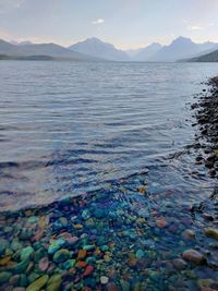 Colorful stones of lake macdonald with mountains in background