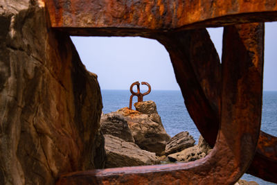 Scenic view of rock formation by sea against clear sky