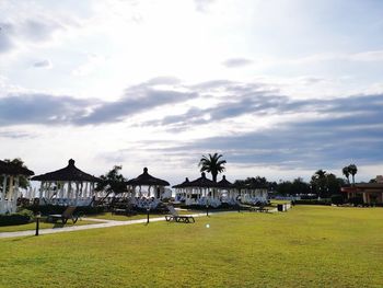 Houses on field by buildings against sky