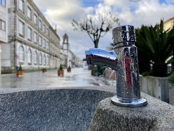 Close-up of fountain against buildings in city