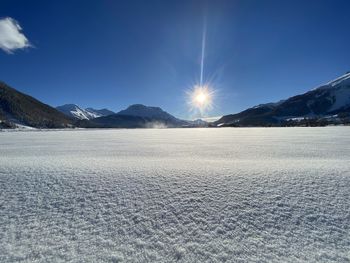 Scenic view of snowcapped mountains against blue sky