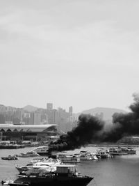 Boats in sea against buildings in city