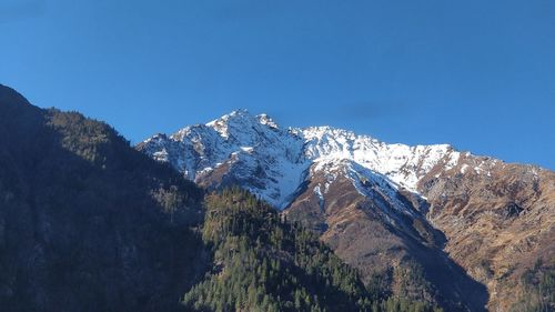 Scenic view of snowcapped mountains against clear blue sky