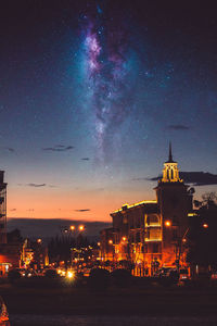 Illuminated buildings in city against sky at night