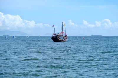 Sailboat sailing in sea against sky