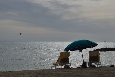 Scenic view of beach chairs against sky