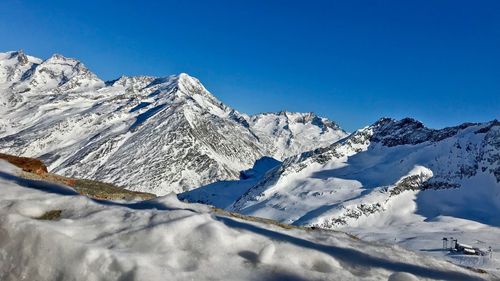 Scenic view of snowcapped mountains against clear blue sky