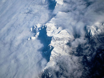 Aerial view of clouds covered snowcapped mountains