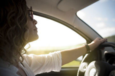 Close up of beautiful woman with sunglasses driving a car.