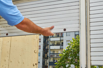 Low angle view of man hand on building