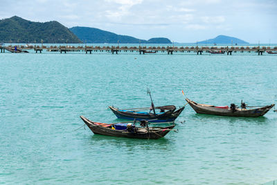 Fishing boats in sea against sky