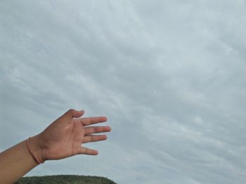 Midsection of person hand against sky