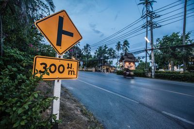 Road sign against sky during sunset