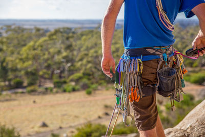 Midsection of man standing with ropes