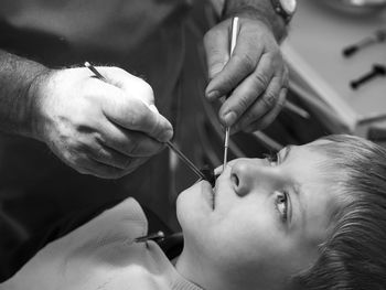 Close-up of dentist examining teeth of boy at clinic