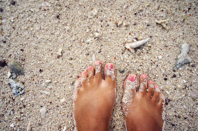 Low section of woman standing at beach