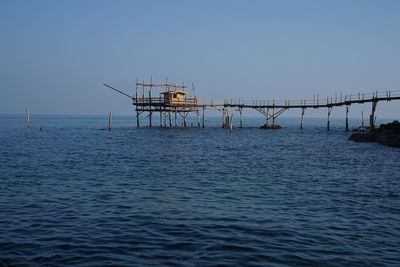 Abandoned pier in sea against sky